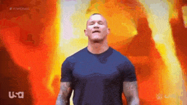 a man in a black shirt is standing in front of a flaming background .