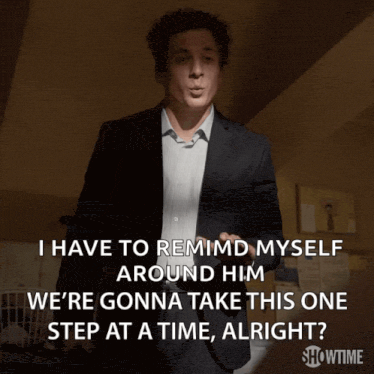 a man in a suit says " i have to remind myself around him " while standing in a dark room