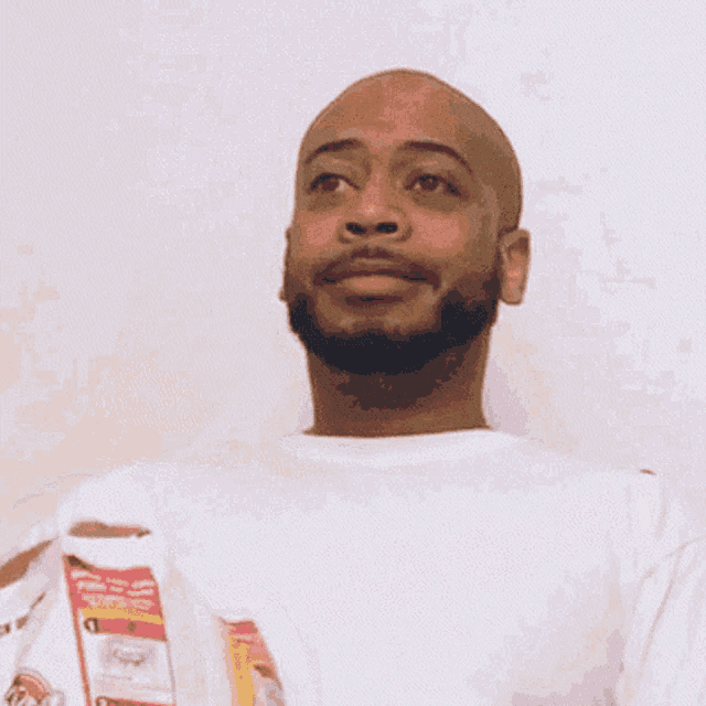a bald man with a beard is holding a bag of chips and smiling