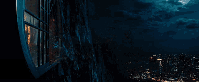a person on a motorcycle is flying through a window at night