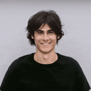 a young man wearing a black t-shirt is looking to the side
