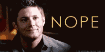 a man in a suit smiles in front of a sign that says nope