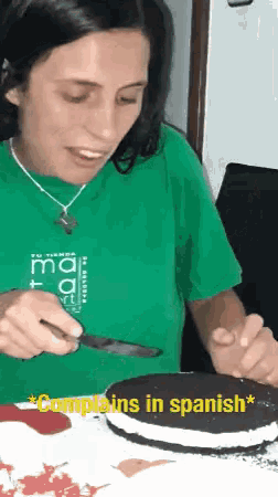 a woman in a green shirt is cutting a cake with the words complains in spanish above her