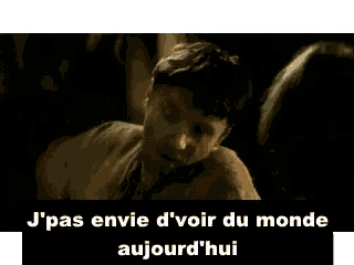 a man in a suit and tie is talking to another man in a dark room in french .