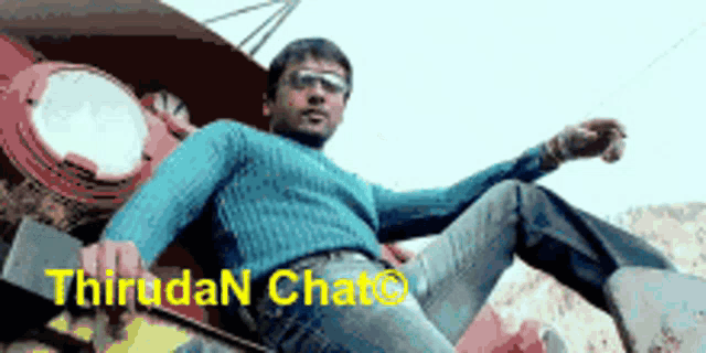 a man in a blue sweater is laying on the ground with the words thirudan chat written on the bottom