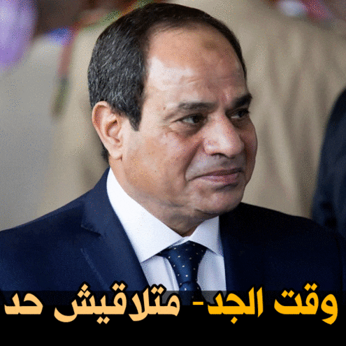 a man in a suit and tie with arabic writing on the bottom right