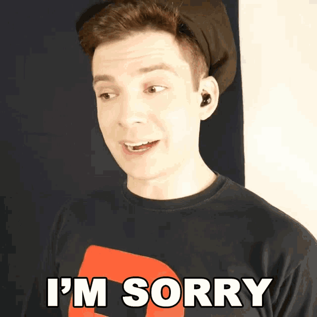 a man wearing a black shirt that says i 'm sorry on it