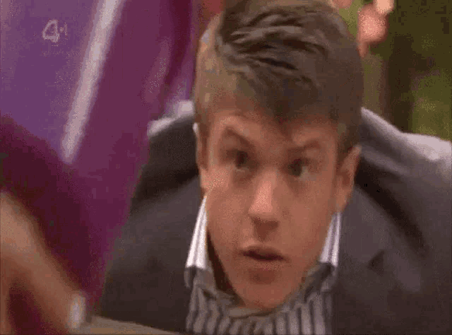 a man in a suit and tie is looking up at something