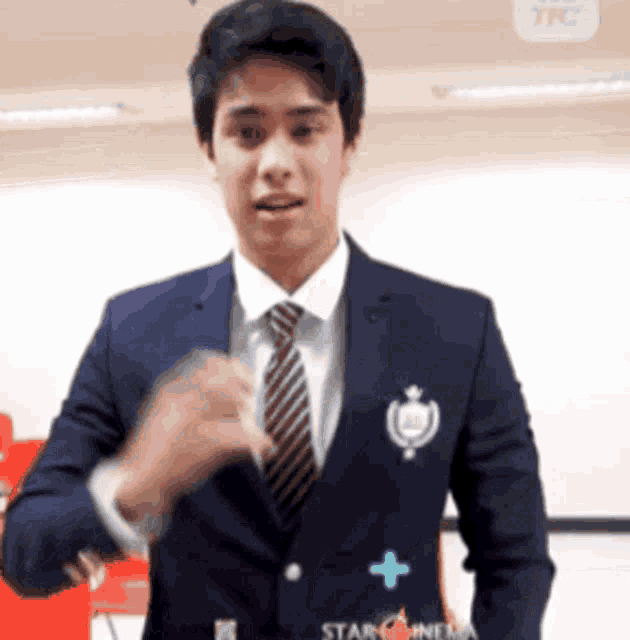 a man in a suit and tie is wearing a star news logo on his jacket