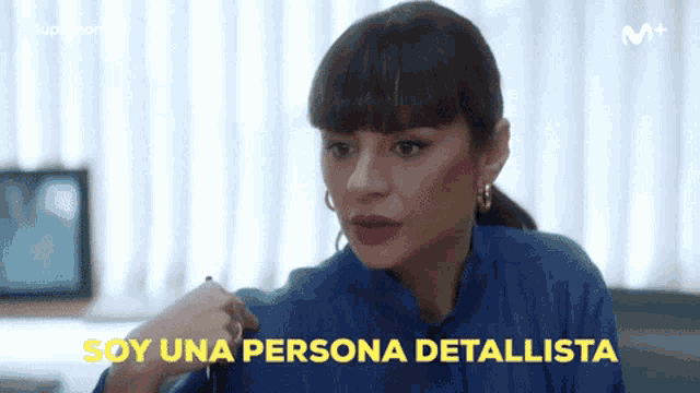 a woman in a blue shirt with the words soy una persona detallista written in yellow