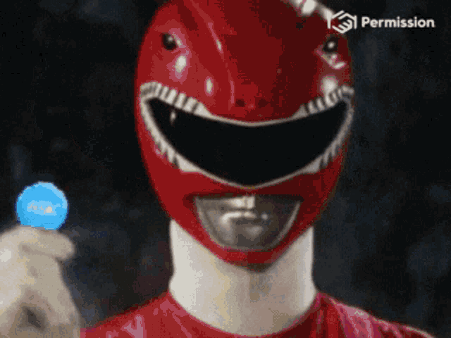 a red power ranger is holding a blue token that says permission