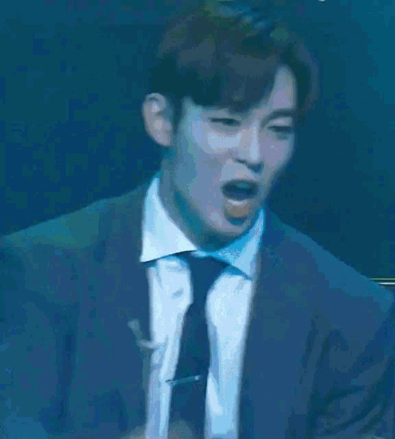 a man in a suit and tie is dancing on a stage
