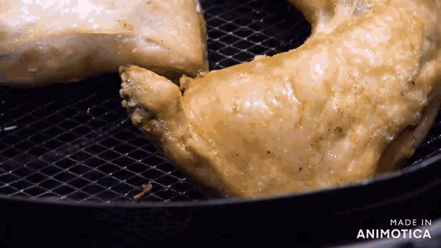 a piece of chicken is being cooked in an air fryer with the words made in animotica on the bottom