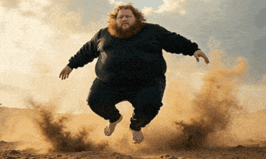 a bearded man is jumping in the air