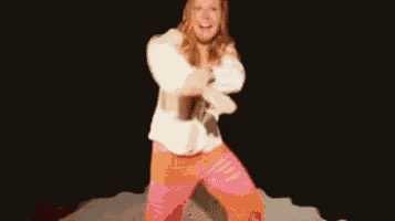 a woman in a white shirt and pink pants is dancing in front of a black background