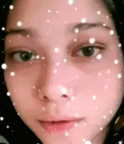 a close up of a woman 's face with snow falling on her face .
