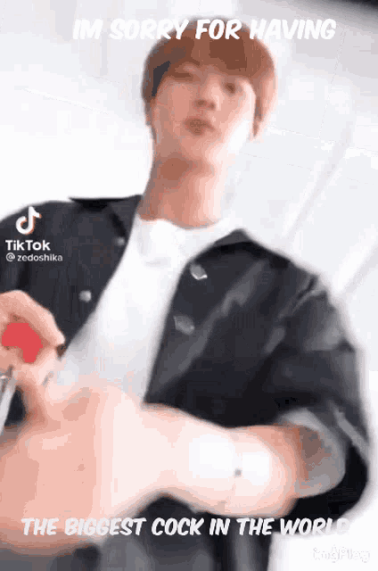 a man is holding a red object in his hand and says i 'm sorry for having
