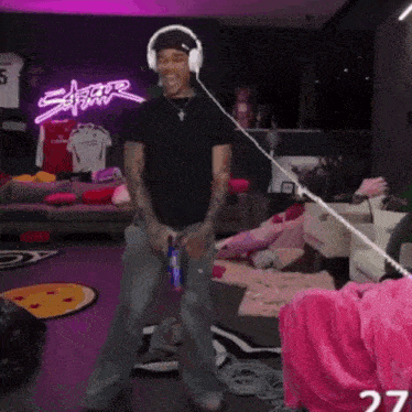 a man wearing headphones is dancing in a room with a neon sign that says ' safari '