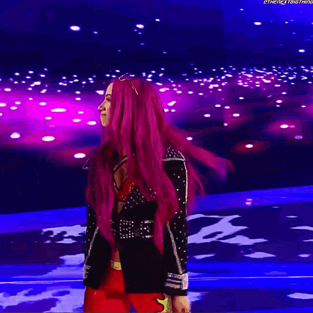 a woman with red hair is standing in front of a purple and blue background