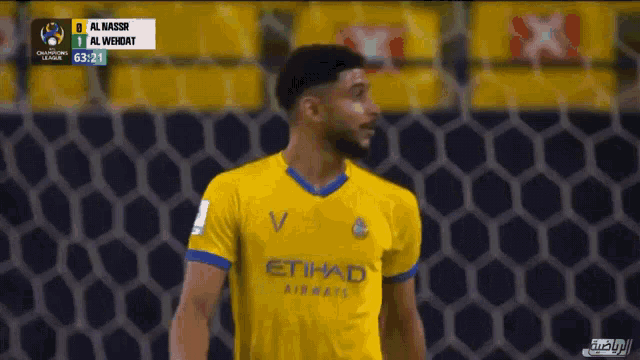 a soccer player in a yellow and blue etihad jersey