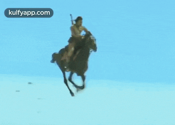 a woman is riding a horse on a beach in the desert .