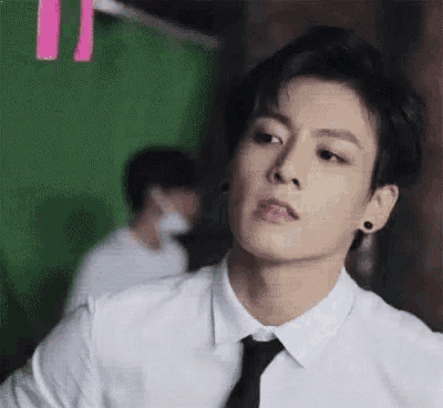 a man in a white shirt and tie is looking at the camera .