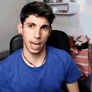 a young man wearing a blue shirt is sticking his tongue out