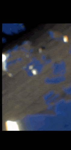 a close up of a shiny surface with a reflection of a light