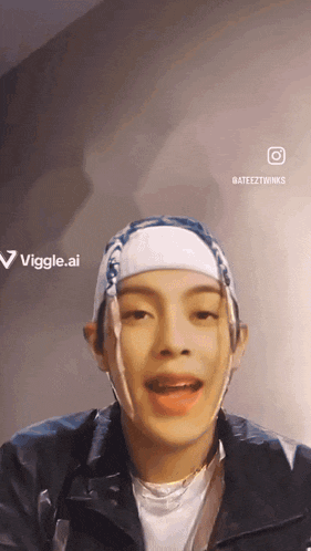 a man with a bandana on his head is talking to the camera ..