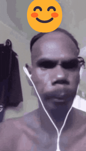 a man wearing headphones has a smiley face on top of his head
