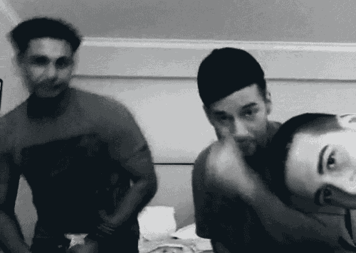 a black and white photo of three men dancing