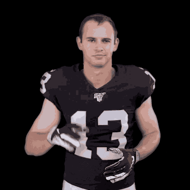 a football player wearing a black jersey with the number 13 on it