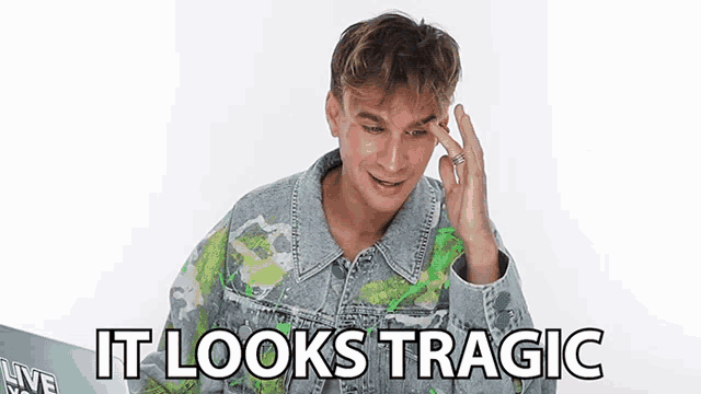 a man in a denim jacket is making a funny face and saying it looks tragic .