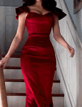 a woman in a red dress is standing on stairs