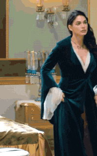 a woman in a green dress is standing in a room