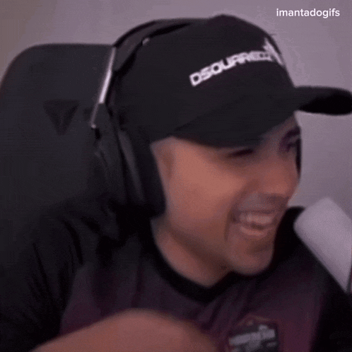 a man wearing headphones and a dsquared hat smiles