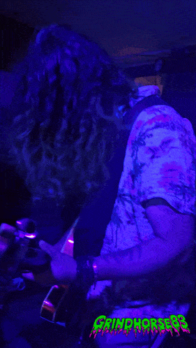 a group of people are dancing in a room with purple lights and the words grindhorse83 on the bottom right