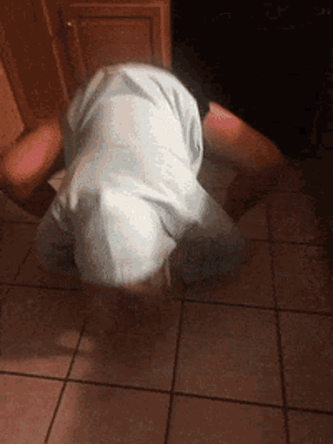 a person in a blue shirt is kneeling down on the floor