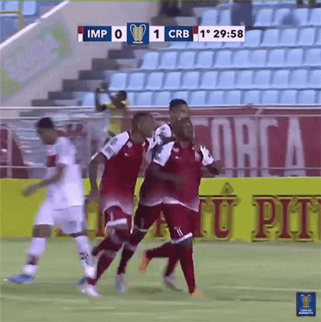 a group of soccer players are celebrating a goal in front of a scoreboard that says imp 0-1 crb