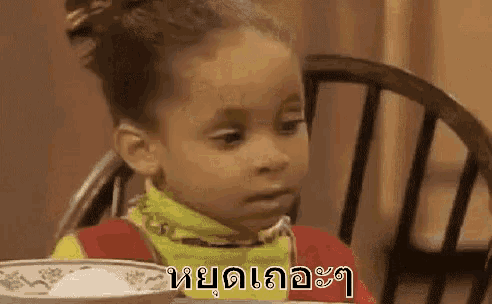 a young girl is sitting at a table with a bowl of food .