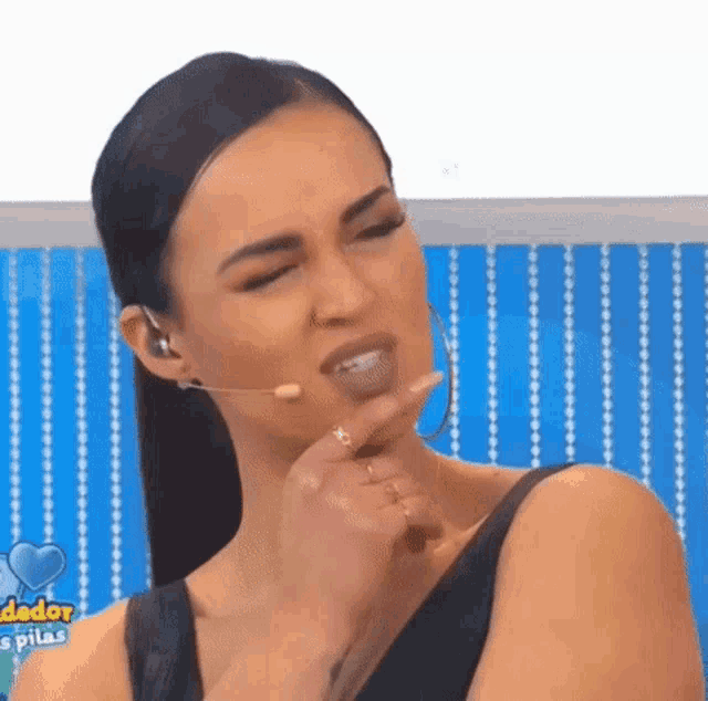 a woman is wearing a microphone and making a funny face