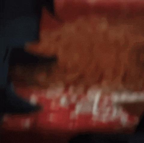 a blurry picture of french fries being poured into a container .