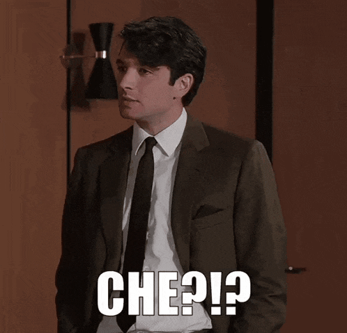 a man in a suit and tie has che written on his chest