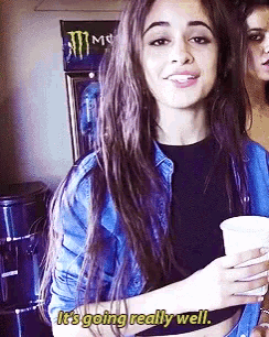 a woman holding a cup with the words it 's going really well below her