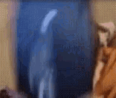 a blurry photo of a person standing in front of a blue wall