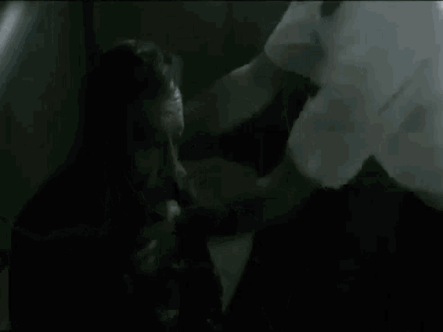 a man is holding another man 's head in a cage .