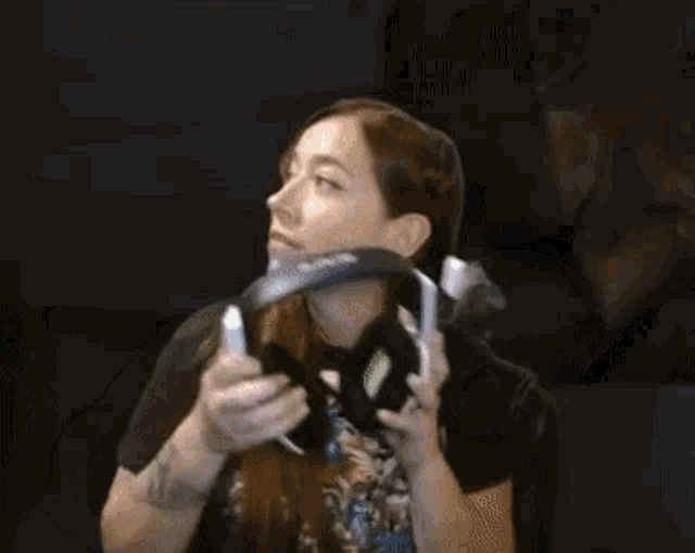 a woman is holding a pair of headphones in front of her face