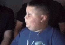 a young boy is making a funny face while watching a movie .