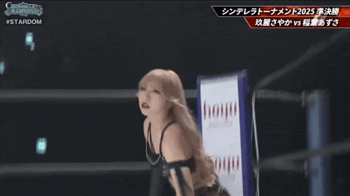 a woman in a wrestling ring with a sign that says hoyu professional