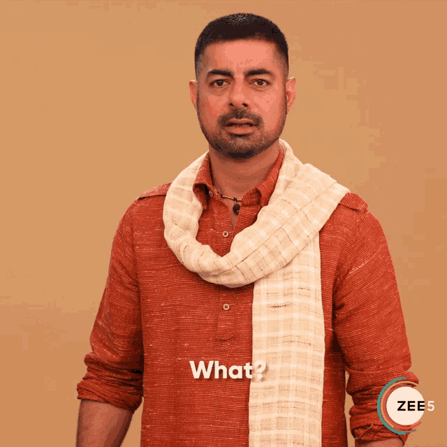 a man wearing a red shirt and a white scarf says what